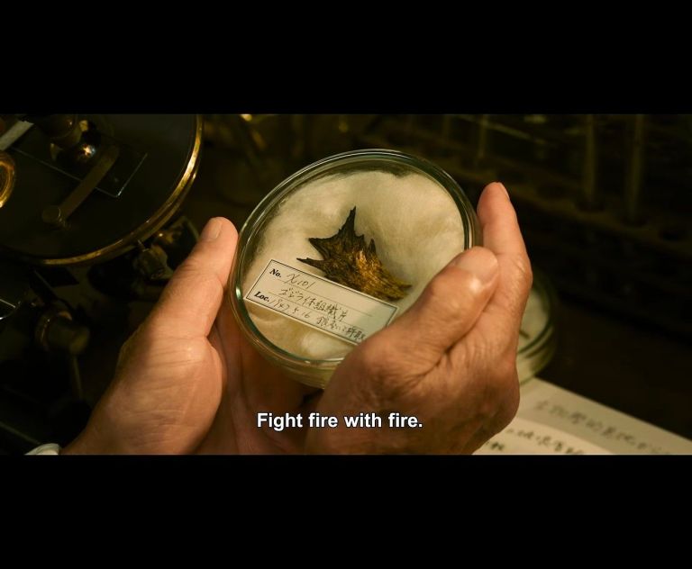 A person holding a glass jar containing a preserved specimen resembling a small, spiky object, with a label visible. The text 'Fight fire with fire.' is displayed below.